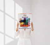 Woman holding a box of Hello Plush chenille yarn showing product scale