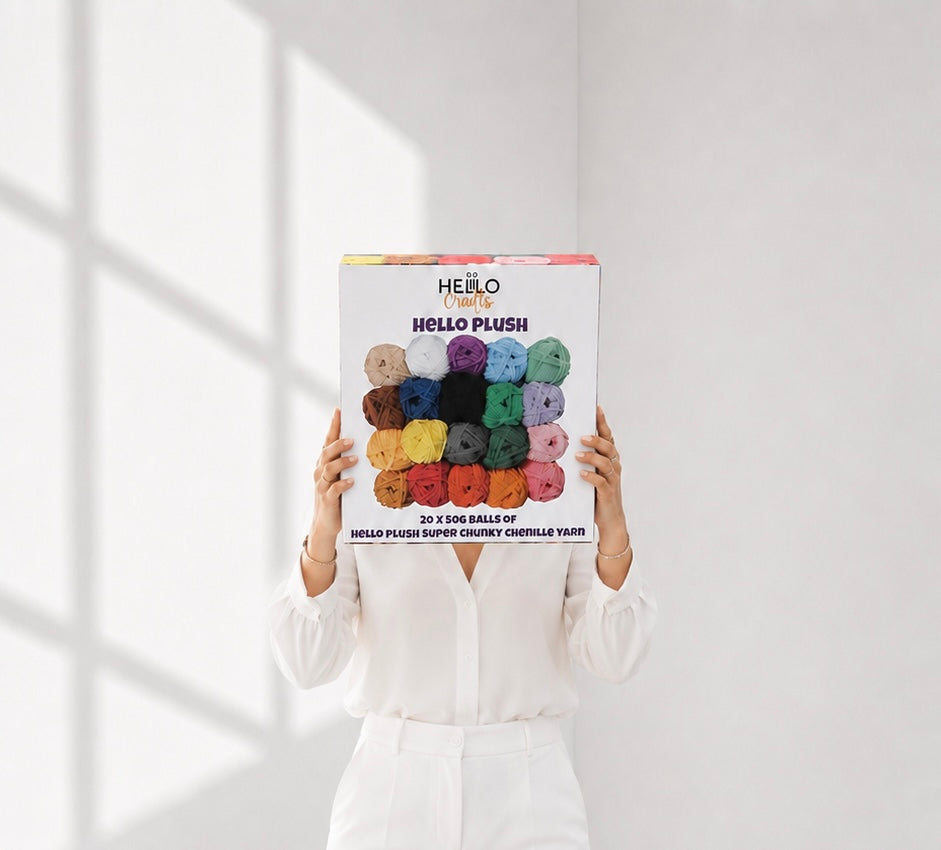 Woman holding a box of Hello Plush chenille yarn showing product scale