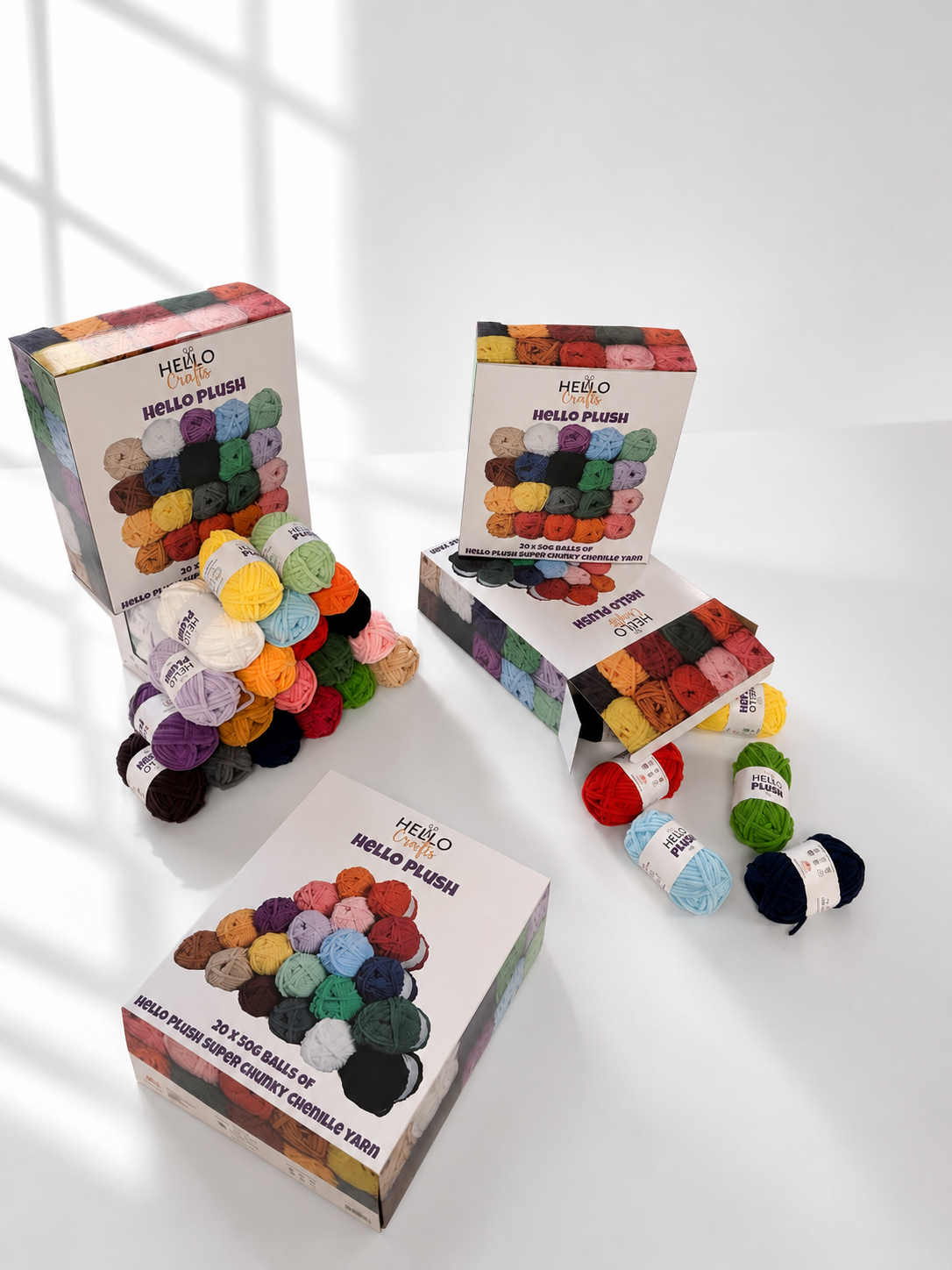 Hello Plush chenille yarn balls in 20 colours next to the box packaging