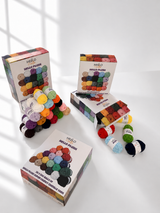 Hello Plush chenille yarn balls in 20 colours next to the box packaging